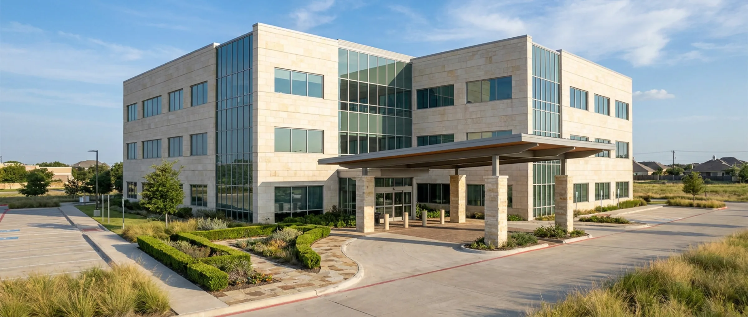 Contemporary medical office building with a stone and glass facade and a covered patient drop-off canopy