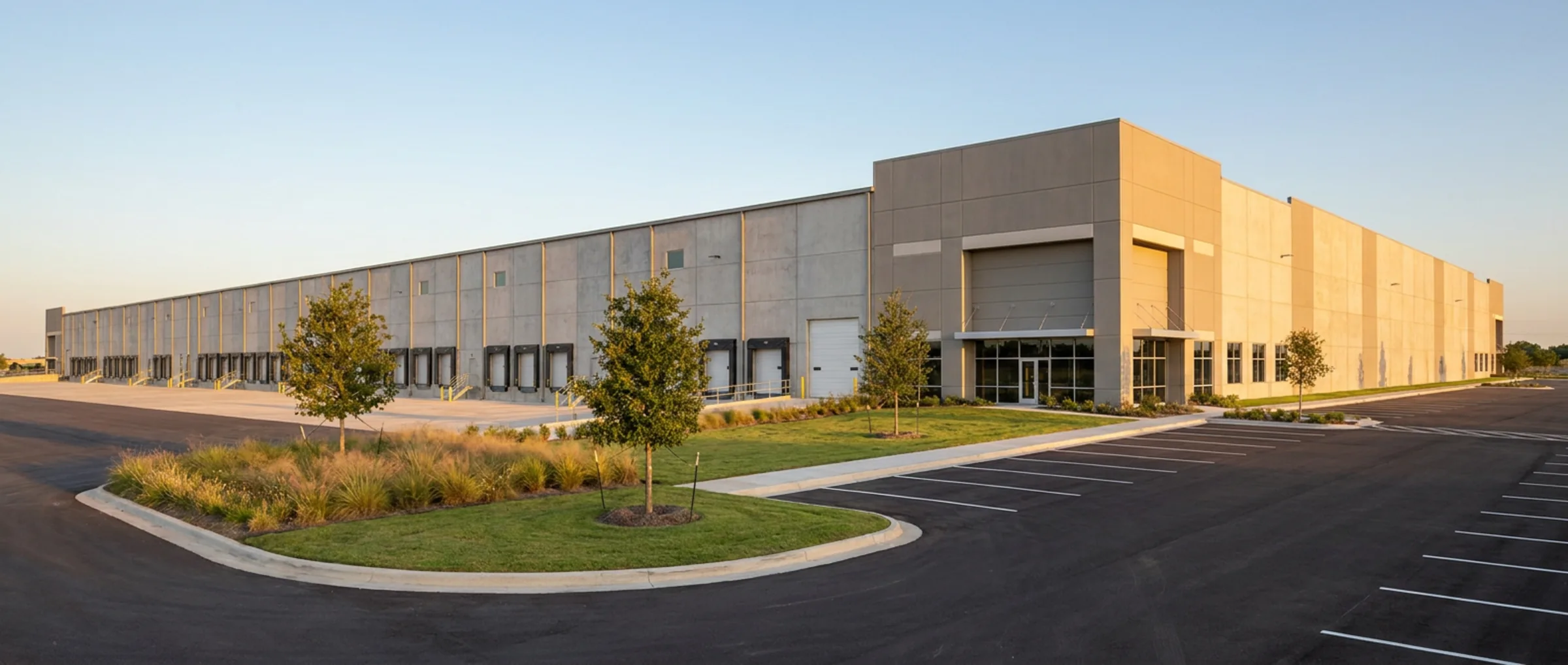 Single-tenant tilt-wall distribution building with a long dock wall, landscaped frontage, and a freshly striped car park